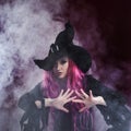 Attractive woman in witches hat and costume with red hair. Halloween Royalty Free Stock Photo