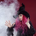 Attractive woman in witches hat and costume with red hair. Halloween Royalty Free Stock Photo
