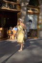 Attractive woman in yellow dress walking on Passeig de GrÃ¯Â¿Â½cia in the Eixample district, busy street in Barcelona, Spain, Europe