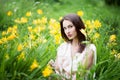 Attractive woman in yellow flowers day-lily field Royalty Free Stock Photo
