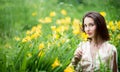 Attractive woman in yellow flowers day-lily field Royalty Free Stock Photo