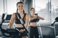 Attractive woman biking in the gym, exercising legs doing cardio workout cycling bikes. Fitness club with training exercise bikes. Royalty Free Stock Photo