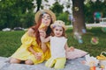 Attractive woman play on green grass in park rest and have fun with little cute child baby girl hold soap bubble blower Royalty Free Stock Photo