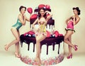 Attractive women posing near big cake. Pinup party. Congratulation concept. Royalty Free Stock Photo
