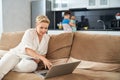 Woman working on laptop while two sons playing together