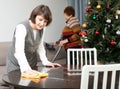 Woman wiping table, elderly mother vacuum cleaning sofa