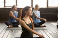 Attractive yogi woman and a Group of people in Matsyendrasana