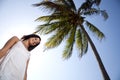 Attractive yougn woman under palm tree