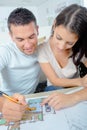 Attractive young adult couple looking at house plans Royalty Free Stock Photo