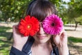 Attractive young adult covering her eyes with red and violet ger Royalty Free Stock Photo