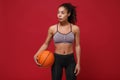 Attractive young african american sports fitness basketball player woman in sportswear working out isolated on red Royalty Free Stock Photo