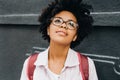 Attractive young african american student female wearing eyeglasses getting ready to go to college, looking up. Beautiful young Royalty Free Stock Photo