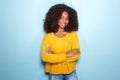 Attractive young african american woman standing with her arms crossed on blue background Royalty Free Stock Photo