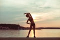 Attractive young African girl athlete running at sunset or sunrise along the beach Royalty Free Stock Photo