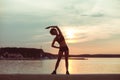 Attractive young African girl athlete running at sunset or sunrise along the beach Royalty Free Stock Photo