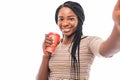 Attractive young african woman holding cup of takeaway coffee, taking a selfie standing isolated over gray background Royalty Free Stock Photo