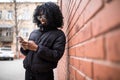 Attractive young African woman holding a mobile phone reading a text message with a serious expression outdoors Royalty Free Stock Photo