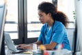 Attractive young afro female doctor talking working with her computer in the consultation Royalty Free Stock Photo