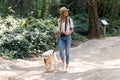 Attractive young amateur photograph woman walking with her dog in the park