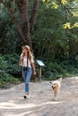 Attractive young amateur photograph woman walking with her dog in the park