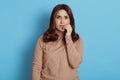 Attractive young anxious unsure hesitant nervous woman biting her fingernails and looking directly at camera, eyes full of fear, Royalty Free Stock Photo