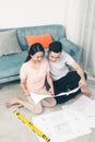 Attractive young asian adult couple looking at house plans. Royalty Free Stock Photo