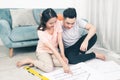 Attractive young asian adult couple looking at house plans. Royalty Free Stock Photo