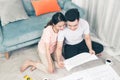 Attractive young asian adult couple looking at house plans. Royalty Free Stock Photo