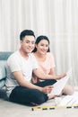Attractive young asian adult couple looking at house plans. Royalty Free Stock Photo