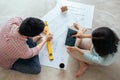 Attractive young asian adult couple looking at house plans. Royalty Free Stock Photo