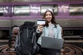 Attractive young Asian backpacker woman with credit card at train station. Ready for travel Royalty Free Stock Photo