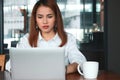 Attractive young Asian business woman with laptop working in modern office. Royalty Free Stock Photo