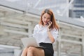 Attractive young Asian business woman using laptop and mobile smart phone for job at outside office. Royalty Free Stock Photo