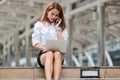 Attractive young Asian business woman using laptop and mobile smart phone for job at outside office Royalty Free Stock Photo