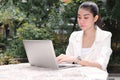 Attractive young Asian business woman working with laptop and mobile smart phone at outside office Royalty Free Stock Photo