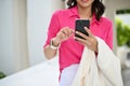 Attractive Asian businesswoman texting to her friends while standing outside of her building Royalty Free Stock Photo