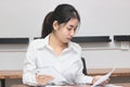 Attractive young Asian businesswoman working on the workplace in office. Thinking and thoughtful business concept. Royalty Free Stock Photo