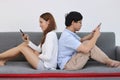 Attractive young Asian couple using mobile smart phone together in living room. Internet technology lifestyle concept. Royalty Free Stock Photo