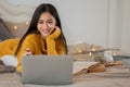 An attractive young Asian female college student is doing homework on her bed in her bedroom Royalty Free Stock Photo