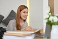 Attractive young Asian female college student doing homework, using laptop computer Royalty Free Stock Photo