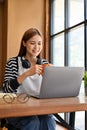 Attractive young asian female student or freelancer remote working in the coffee shop Royalty Free Stock Photo