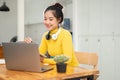 An attractive young Asian female university student using her digital tablet and laptop at a table Royalty Free Stock Photo
