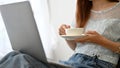 Attractive young Asian female using laptop computer while sipping a hot coffee Royalty Free Stock Photo