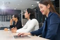 The attractive young Asian girl working on a laptop with group of diverse employees business people team during a brainstorming Royalty Free Stock Photo