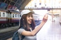 Attractive young Asian lady tourist with model airplane at train station. Travel lifestyle concept Royalty Free Stock Photo