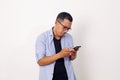 Attractive young Asian man reading texting chatting on his phone, bad news, sad crying expression Royalty Free Stock Photo