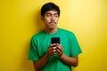 Attractive young asian man reading texting chatting on his phone, bad news, sad crying expression Royalty Free Stock Photo