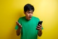 Attractive young asian man reading texting chatting on his phone, bad news, sad crying expression Royalty Free Stock Photo