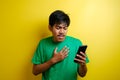 Attractive young asian man reading texting chatting on his phone, bad news, sad crying expression Royalty Free Stock Photo