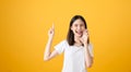 Attractive young asian woman announcing with hands to the mouth  and telling a secret. Royalty Free Stock Photo